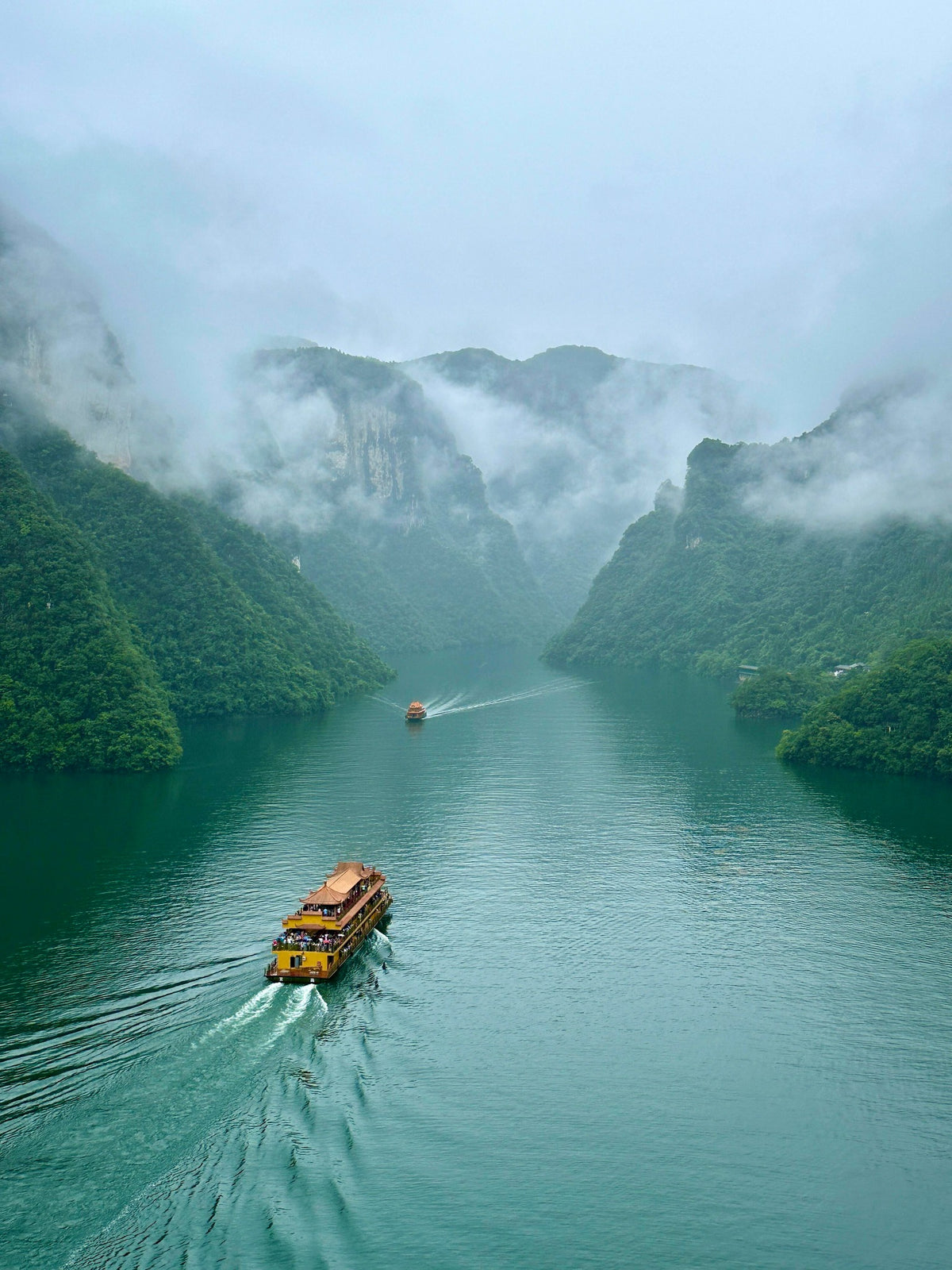 Misty Qingjiang River cruise through forested mountains in Enshi, Hubei